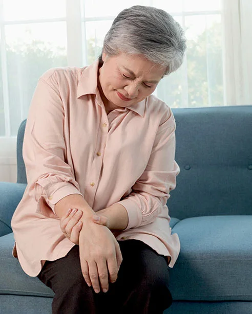 A woman easing discomfort in her shoulder, a common site of everyday joint pain